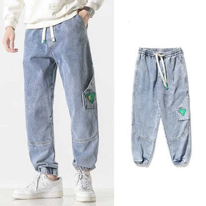 Men's loose-fit tapered cotton trousers in black showing mid-waist design and tapered leg opening