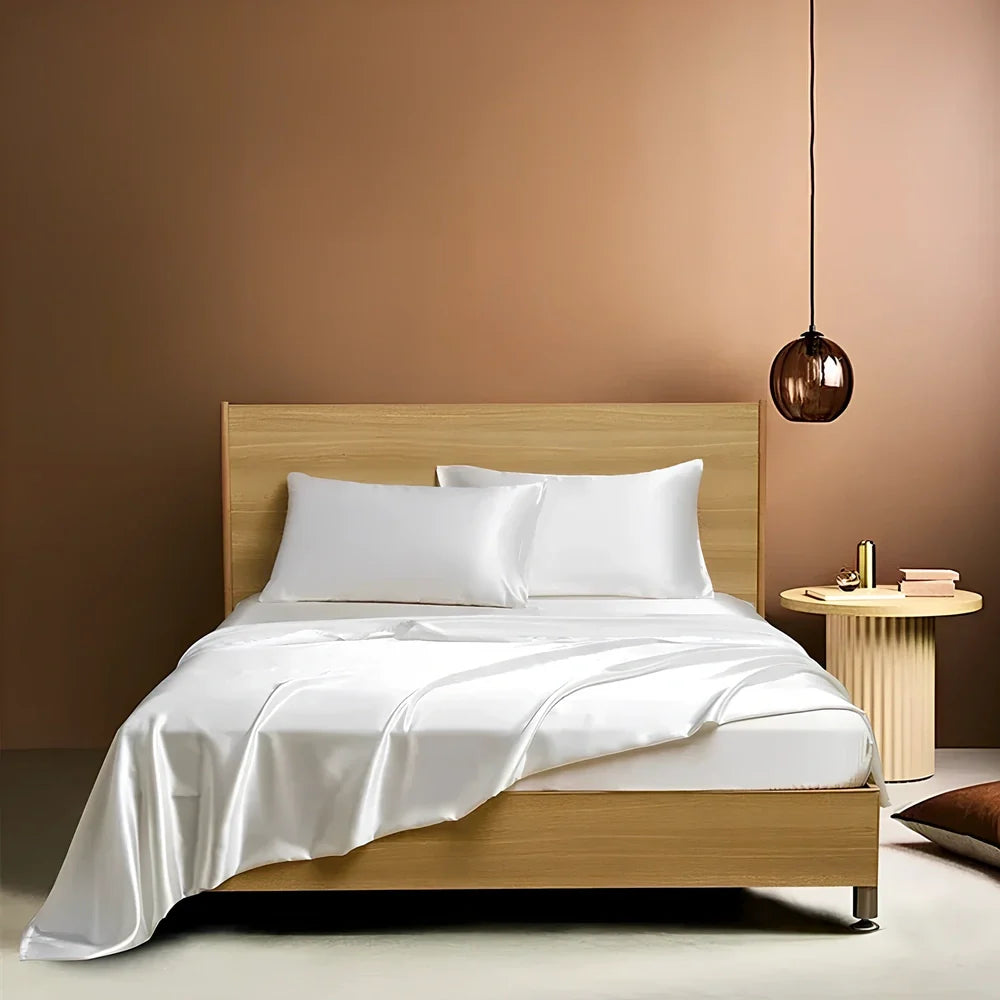 Navy blue floral pattern silk bedding set with quilt cover, fitted sheet, and two pillowcases on bed