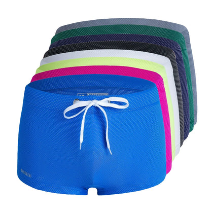 Men's low waist boxer style swimming trunks in nylon, available in multiple solid colours.