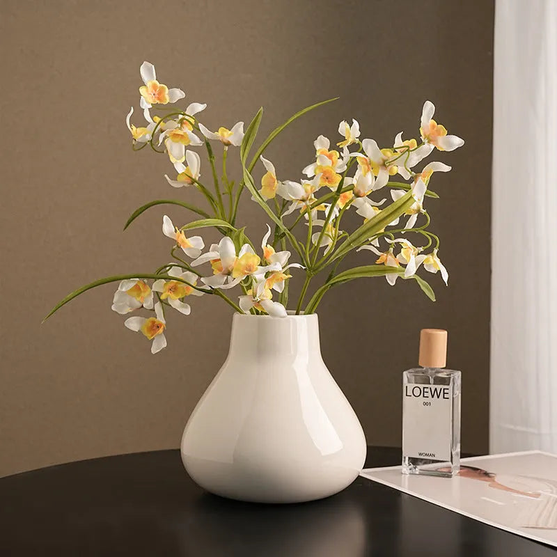 Ceramic round belly French high sense decorative household vase with coloured glaze finish, available in black or white, includes two artificial orchid stems for immediate display.