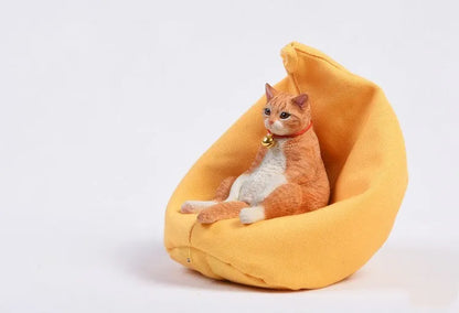 Lazy cat ornament on miniature sofa for car dashboard decoration, 7.5cm high with fabric art detailing