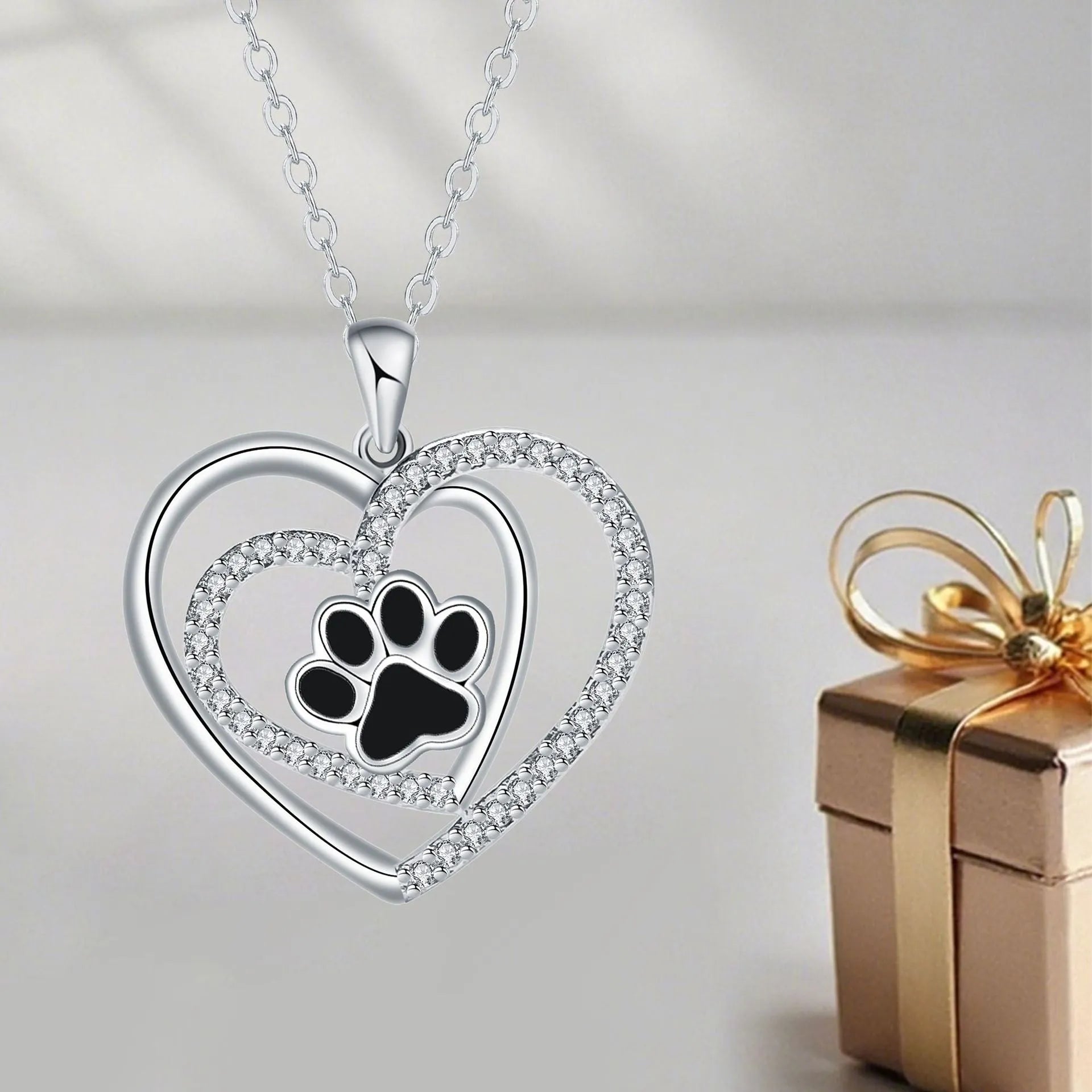 Copper heart pendant necklace with engraved dog paw print on a cross chain.