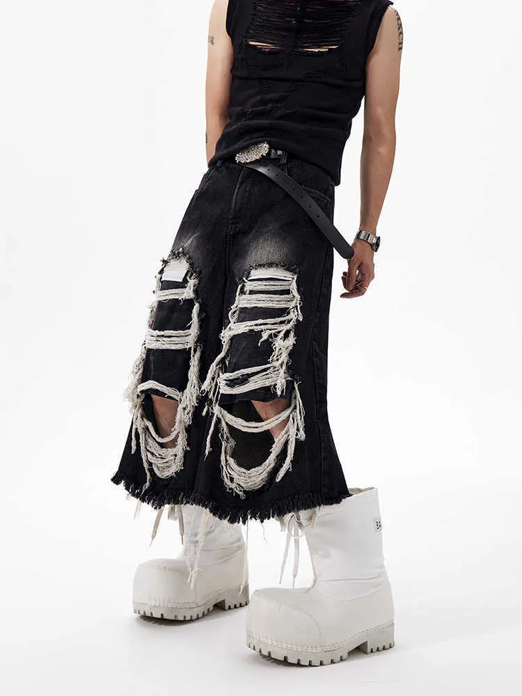 Black cropped wide-leg jeans with a mid-high waist, ripped patch detail, and a loose fit on a model.