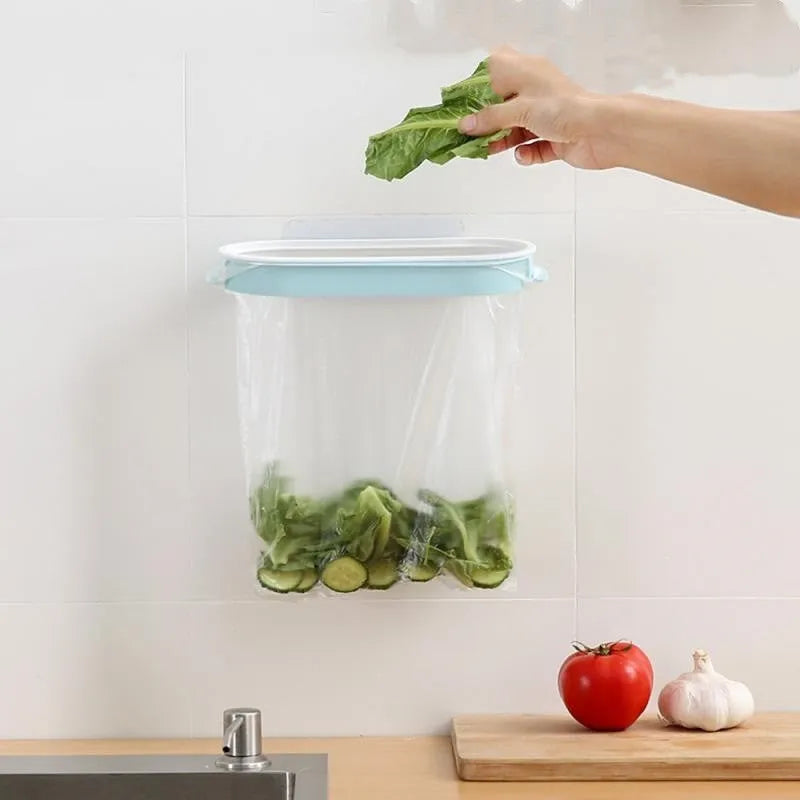Blue or pink plastic kitchen garbage bag storage rack mounted on a cabinet or bench for organising carrier bags