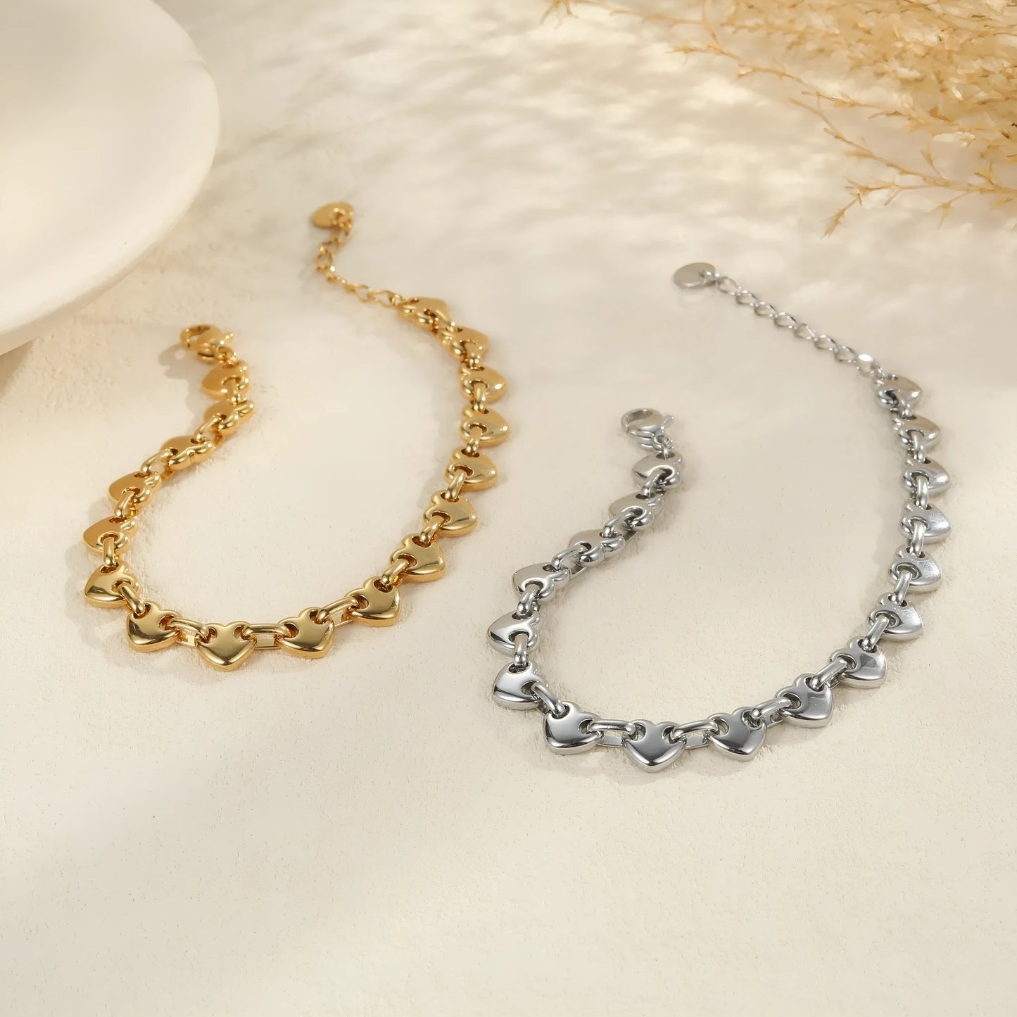Women's hollow heart bracelet in stainless steel with 18K gold plating, shown in colour block, gold, and steel finishes