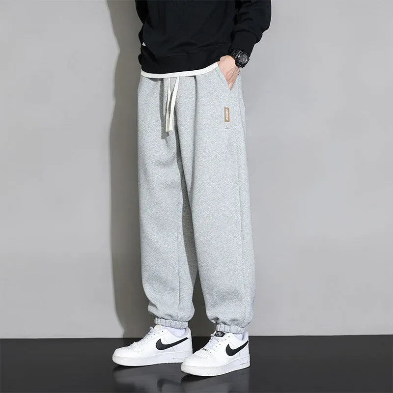 Men's loose gray casual sports trousers with drawstring waist on a hanger