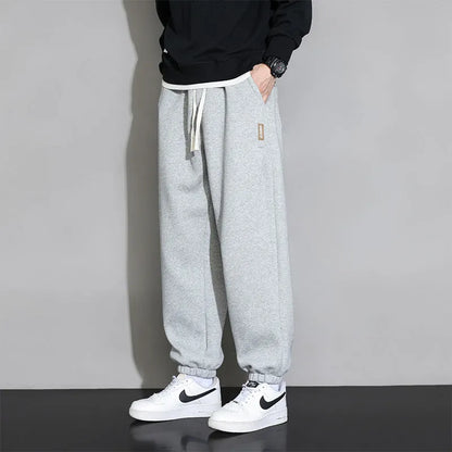 Men's loose gray casual sports trousers with drawstring waist on a hanger