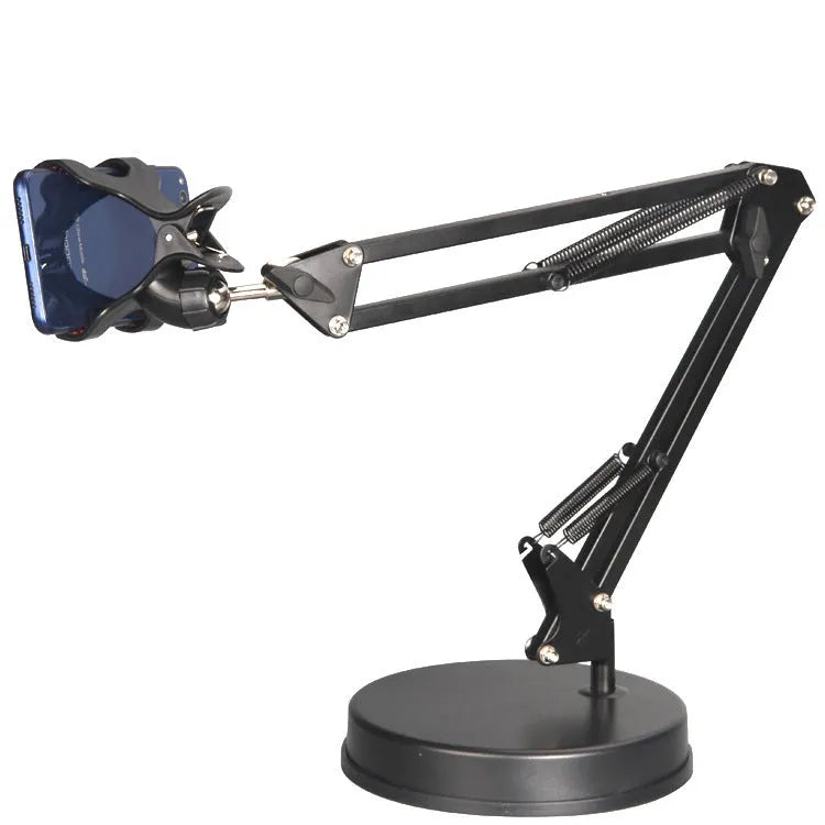 Black universal phone stand with long metal arm and heavy round base on a wooden desk