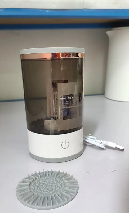 Grey and white portable electric makeup brush cleaner with USB charging cable.