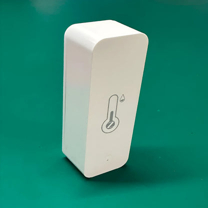 Compact white WiFi temperature and humidity sensor for smart home monitoring.