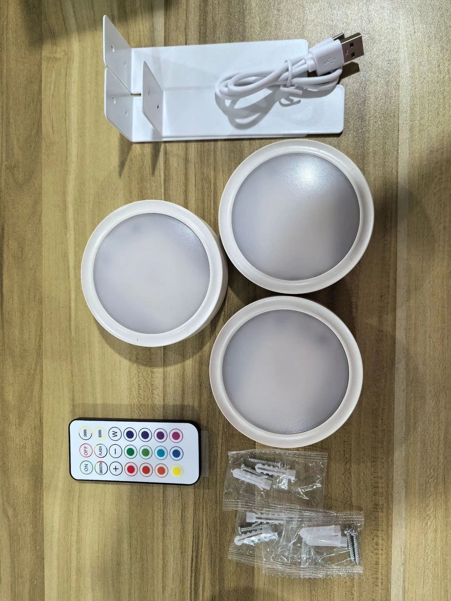Black magnetic LED painting lamp with remote control on a white wall.