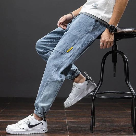 Men's blue cargo jeans with straight-leg fit, micro-elasticity fabric, and cargo pockets on a hanger.