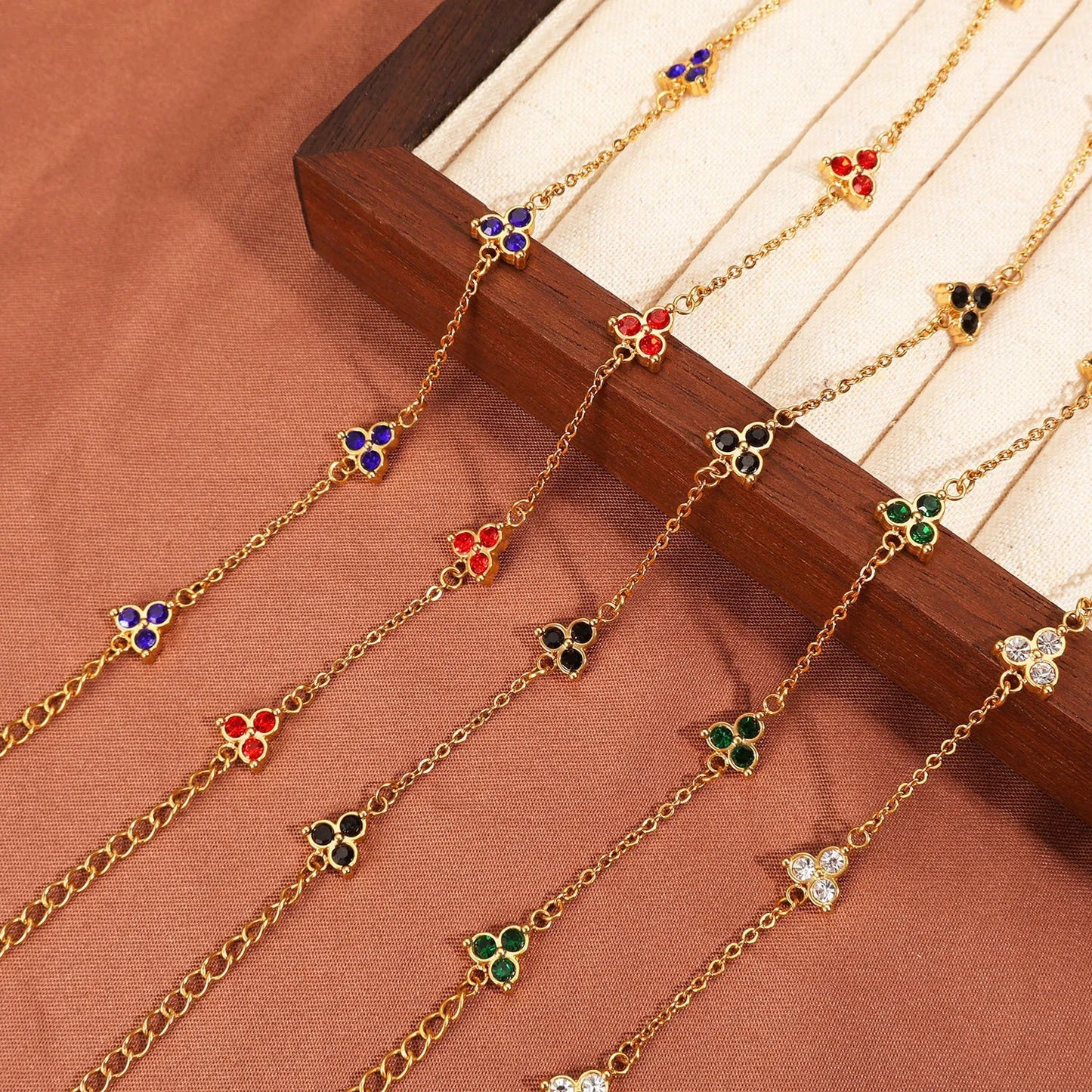 Women's stainless steel bracelet with three triangle-shaped charms in different coloured stone settings