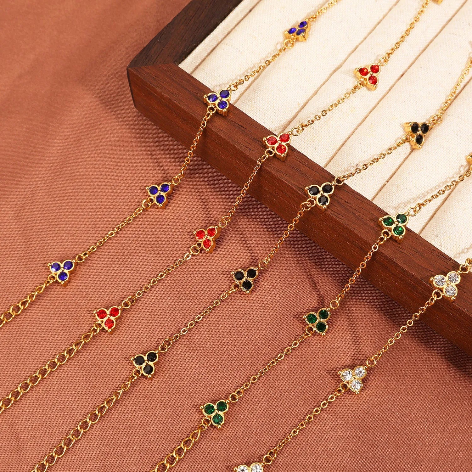 Women's stainless steel bracelet with three triangle-shaped charms in different coloured stone settings