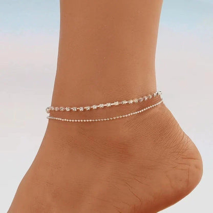 Women's geometric bead anklet with adjustable chain in gold and silver options.