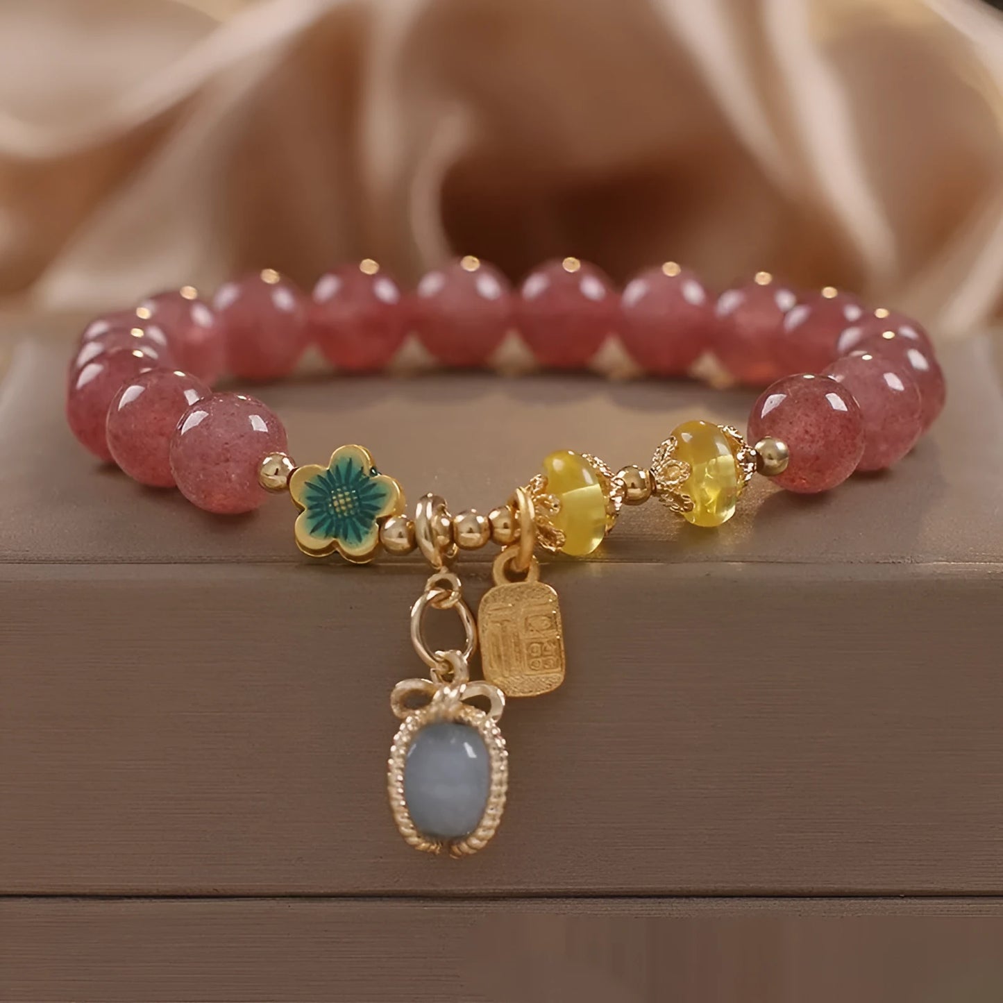 Red women's bracelet with strawberry quartz beads and rhinestones on an alloy chain.