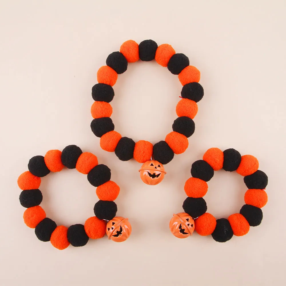 Orange pumpkin-shaped cat collar with a naughty cat face print, laid flat.
