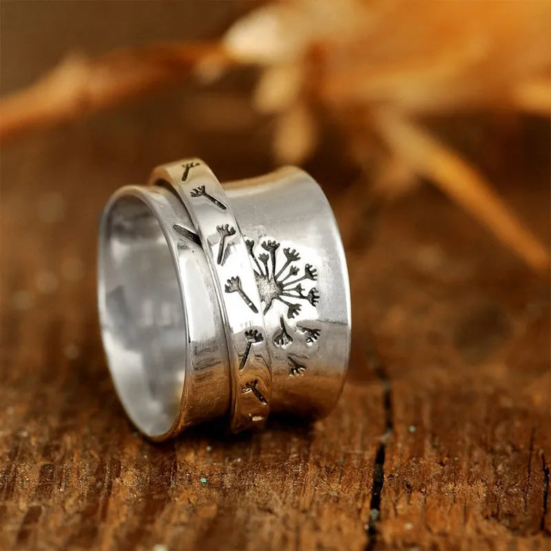 Silver-coloured rotating flower ring on finger showing adjustable floral element