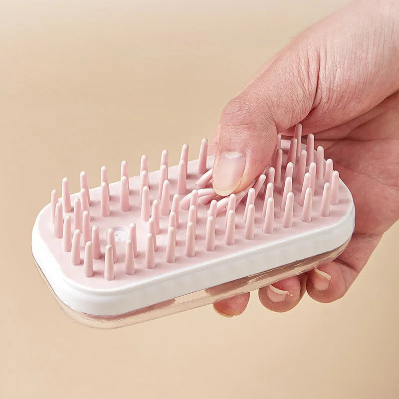 Flexible silicone pet bath brush with an adjustable hand strap in grey and pink colour options.
