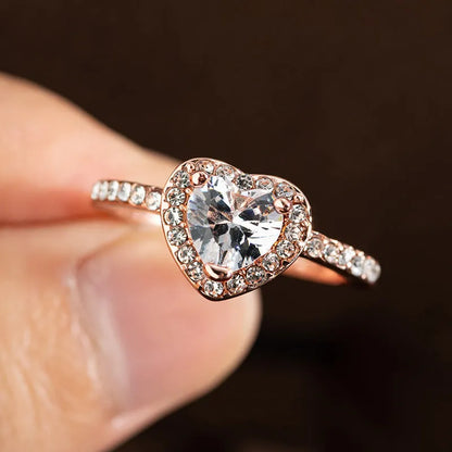 Women's heart-shaped crystal wedding ring in rose gold or silvery on a white background.