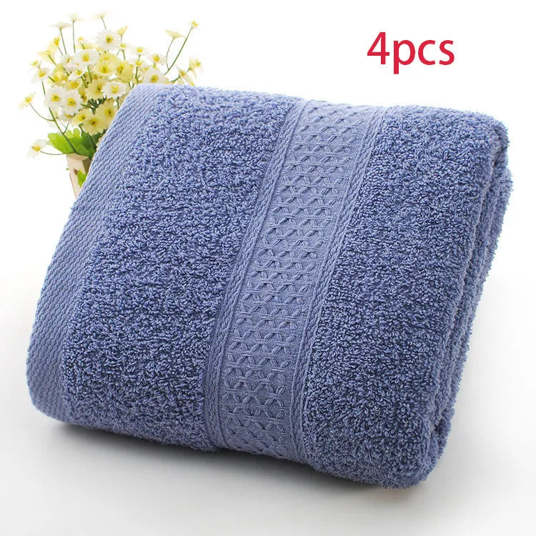 A stack of thickened cotton bath and beach towels in various colours including apple green, dark blue, and light pink.
