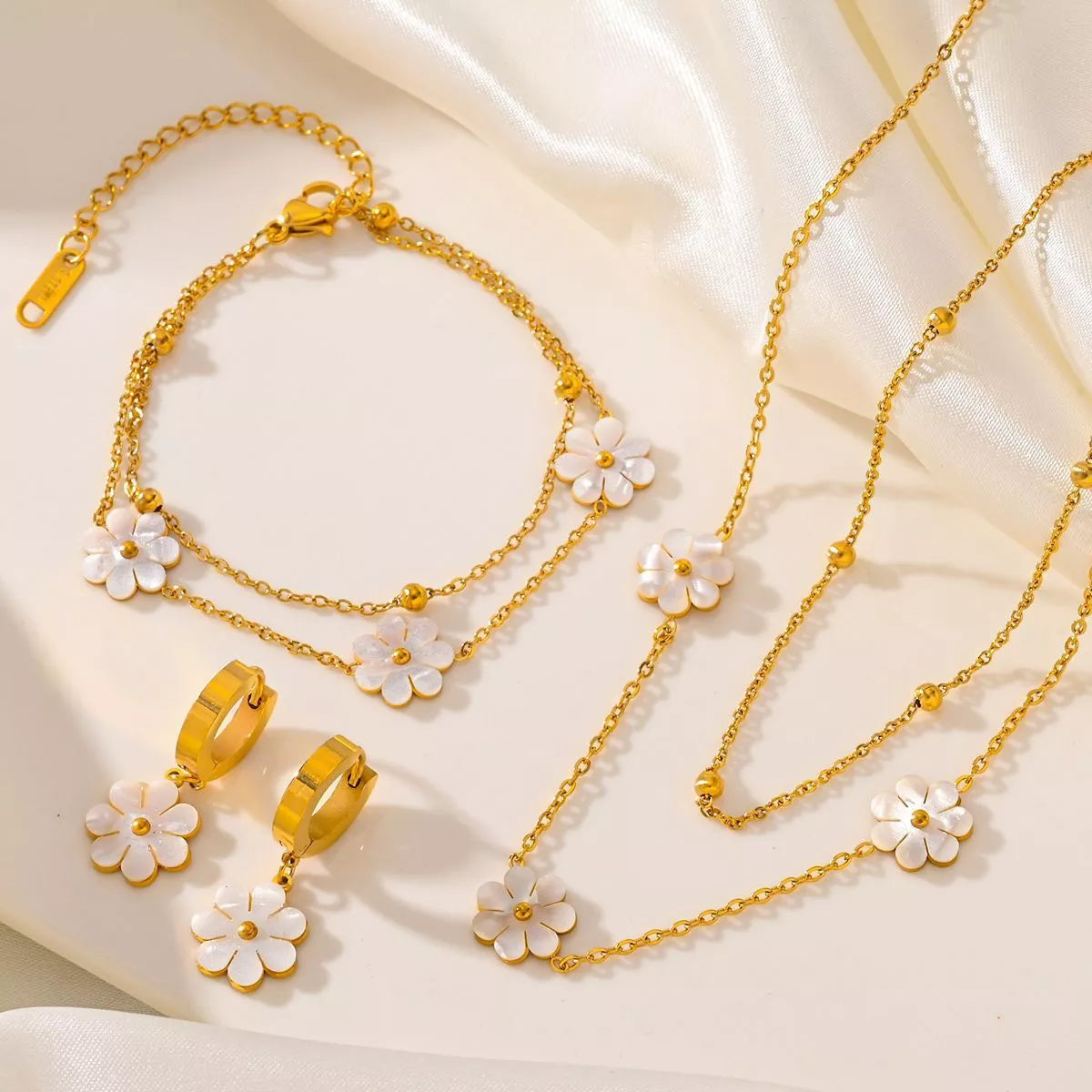 Stainless steel daisy flower jewelry set with necklace, bracelet, and earrings in electroplated gold finish