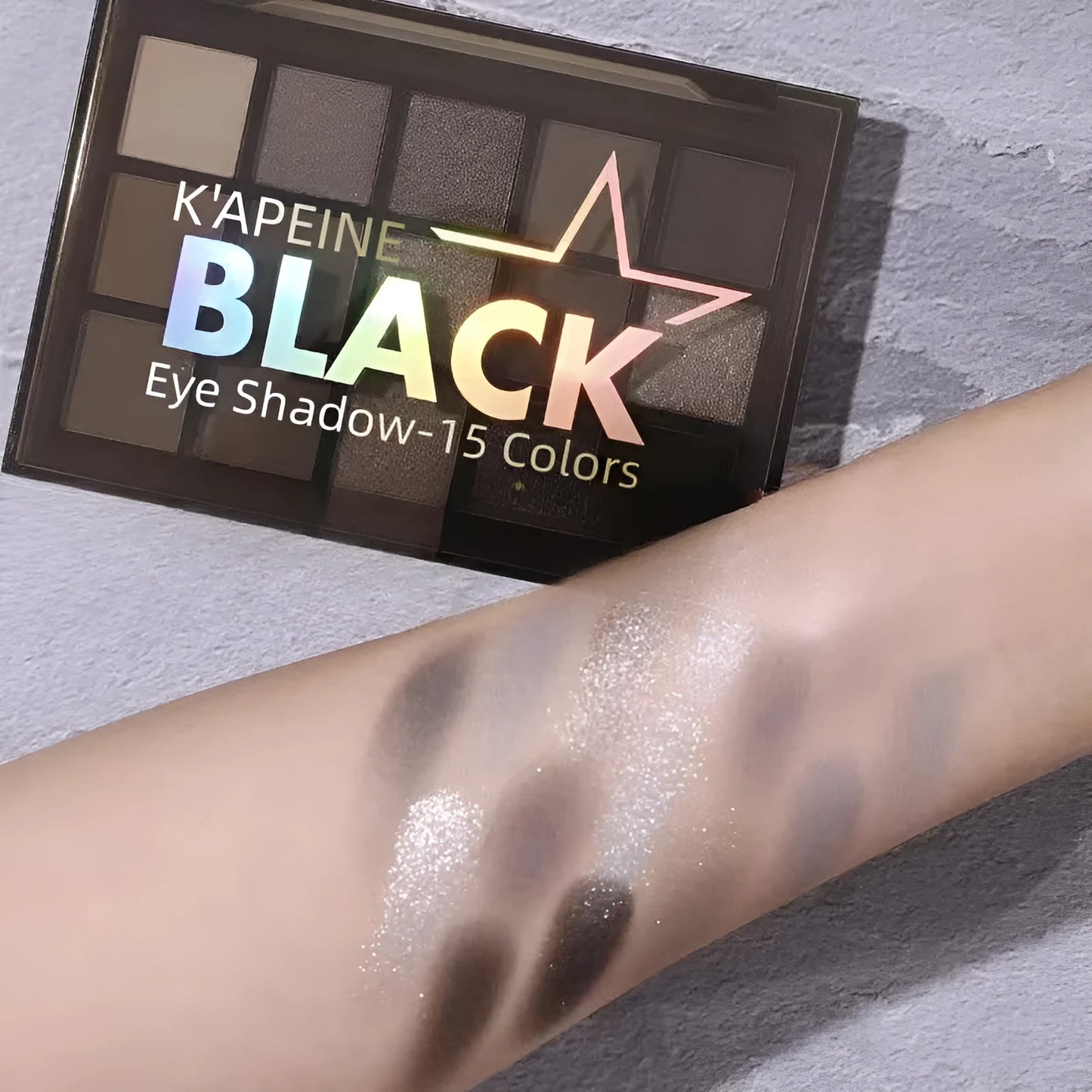 Open 15-colour eyeshadow palette showing shimmer and matte pans in browns, blues, and earth tones
