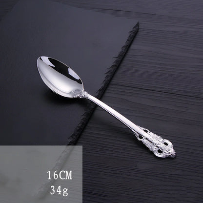 Four-piece stainless steel cutlery set showing main knife, fork, spoon, and teaspoon with mirror finish