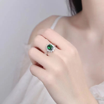 A women's copper ring with a flower design and a central zirconium stone, shown in green, blue, and red colour options.