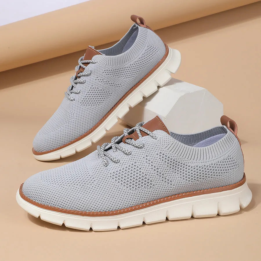 Men's grey and black low-top casual sneakers with a breathable mesh fabric upper.