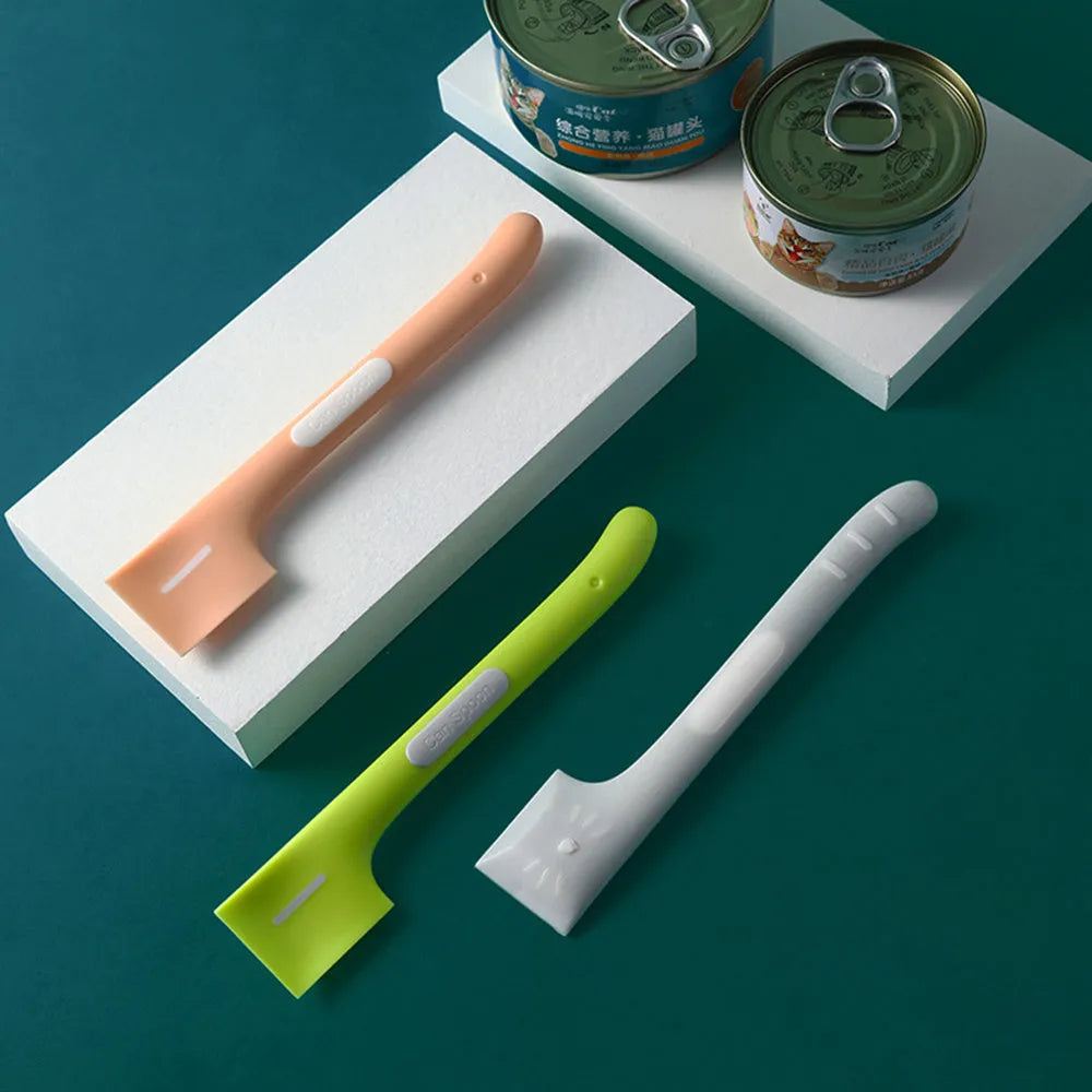 Green long-handled plastic spoon for scooping pet food from a can.