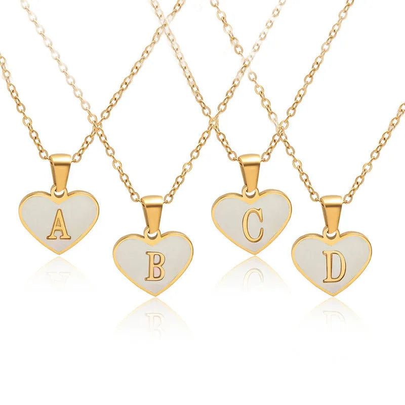 Gold-plated clavicle necklace with a white shell heart pendant, personalised with a letter from A to Z.