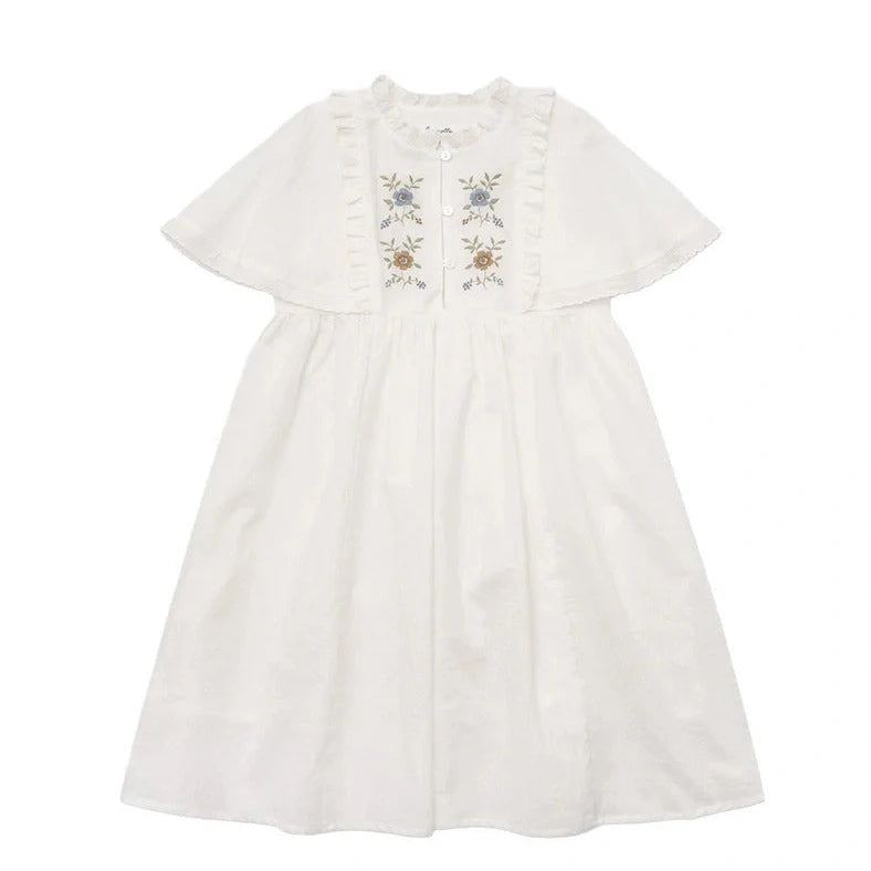 White cotton girls dress with embroidered skirt detail, short sleeves, and Western style silhouette