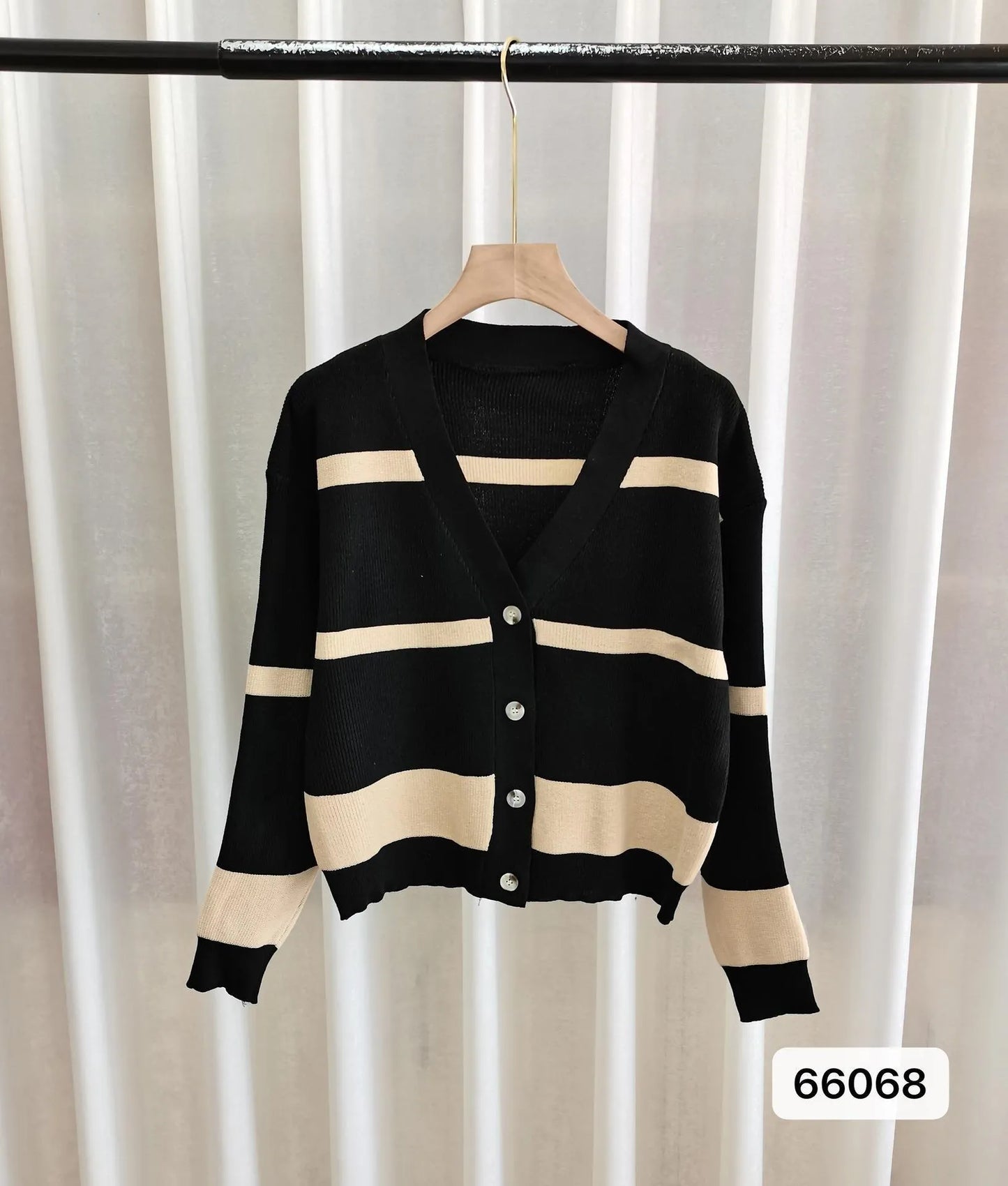 Women's black and white striped V-neck cardigan with buttons, showing a textured 3D knit pattern.