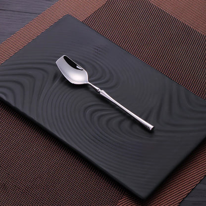 Four-piece stainless steel cutlery set showing main knife, fork, spoon, and teaspoon with mirror finish