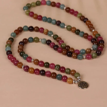 Close-up of a multi-layer beaded bracelet with 108 tourmaline beads and alloy string, showing lotus hanging detail.