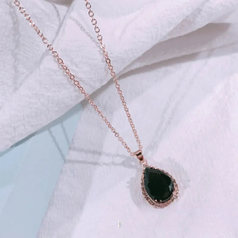 Rose gold geometric water drop pendant necklace on a model, showing adjustable chain and sparkling stone inlay.