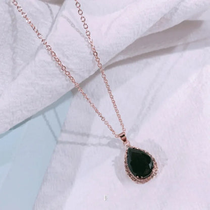 Rose gold geometric water drop pendant necklace on a model, showing adjustable chain and sparkling stone inlay.