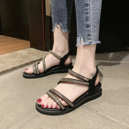 Women's silver sandals with elastic band and sequin accents, showing rubber sole and round toe design