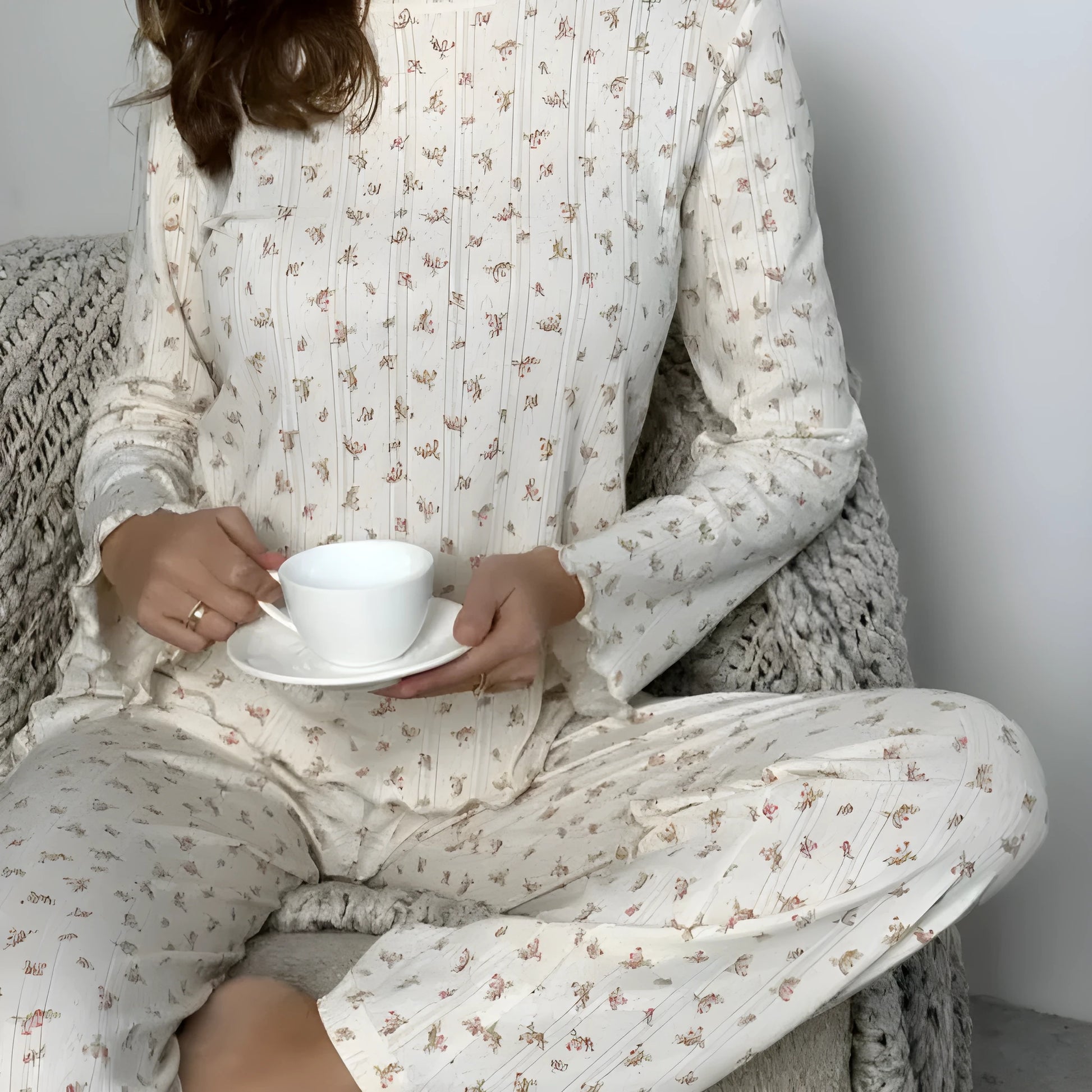 White floral print women's loungewear set with bell sleeve top and wide-leg trousers laid flat.