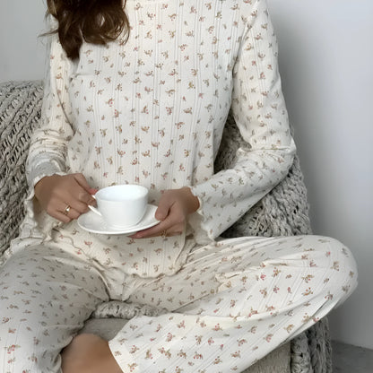 White floral print women's loungewear set with bell sleeve top and wide-leg trousers laid flat.