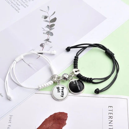 Magnetic suction couple bracelet pair in alloy with an electroplated finish, showing example designs like a crown and love lock.