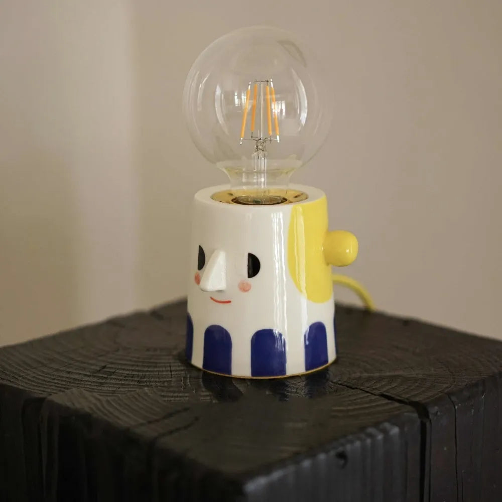 Handmade ceramic lamp with ball headlight design on a bedside table