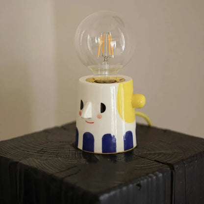 Handmade ceramic lamp with ball headlight design on a bedside table