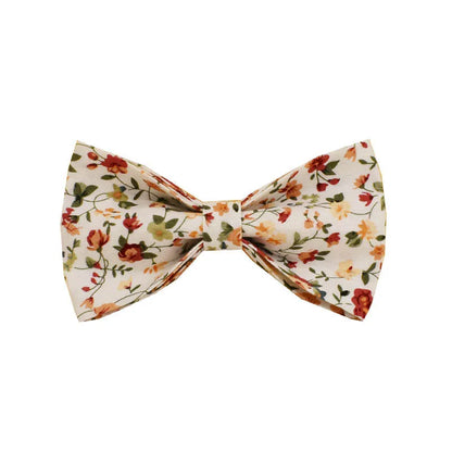 Small white flower patterned dog collar, leash, vest, bow, and poop bag holder set laid out flat.
