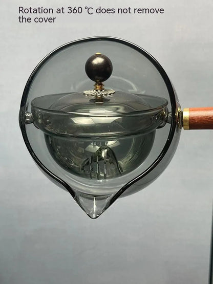 Glass teapot with wooden handle showing transparent borosilicate construction and removable infuser