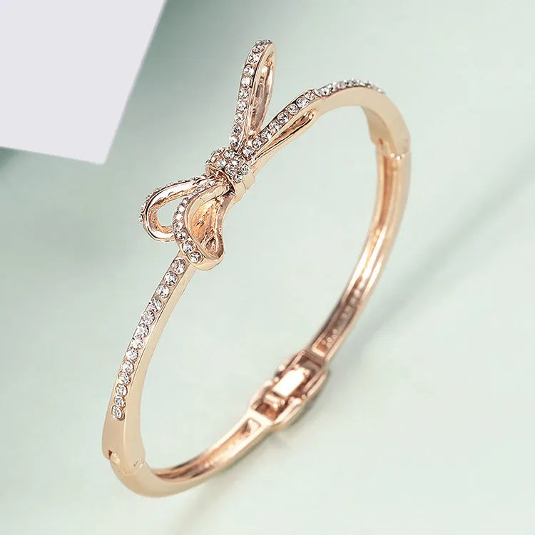 Women's rose gold alloy bracelet with bow design, diamond accent, and electroplated copper finish