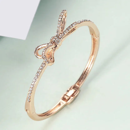 Women's rose gold alloy bracelet with bow design, diamond accent, and electroplated copper finish
