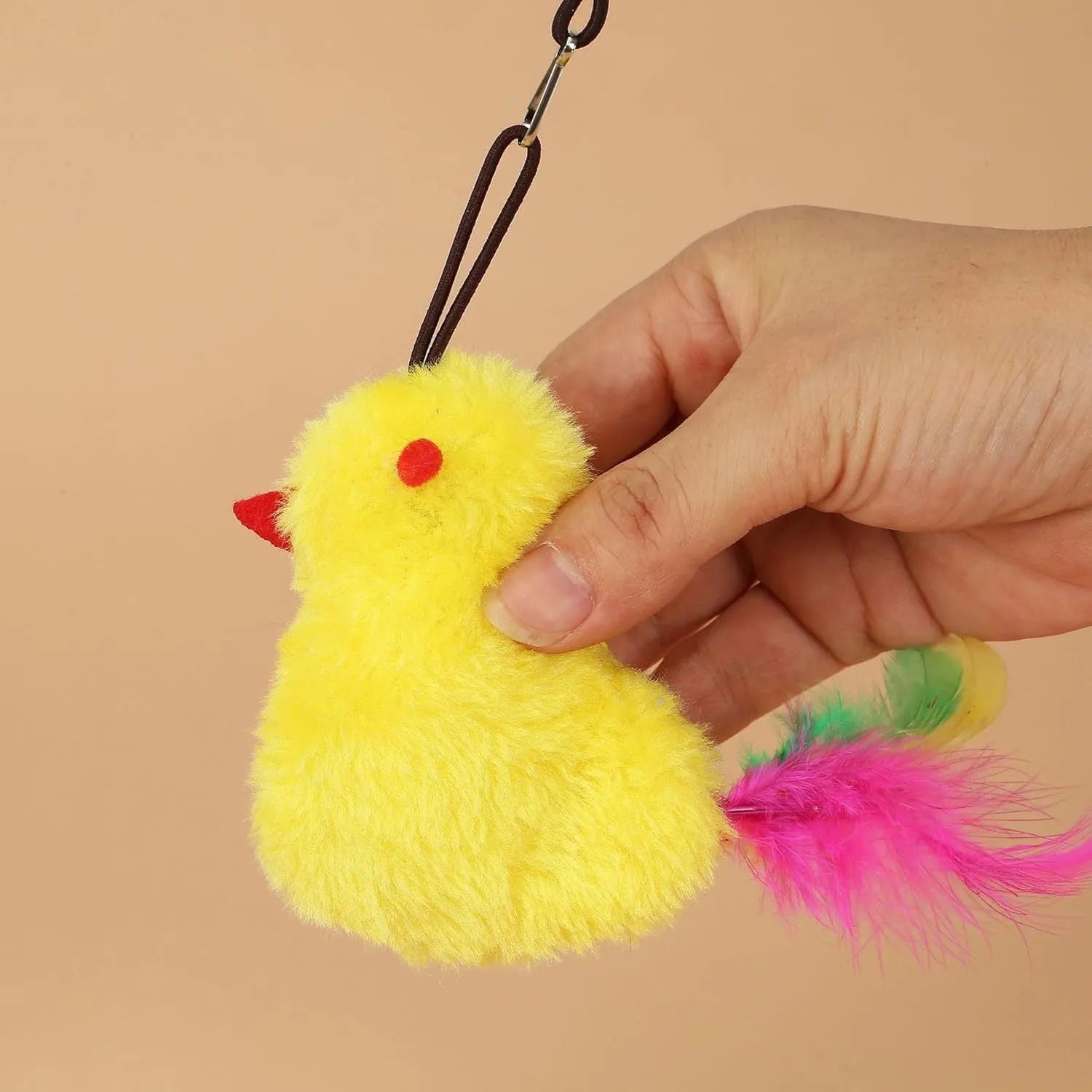 Grey and yellow interactive cat toy hanging on door frame with retractable elastic rope and treat dispenser