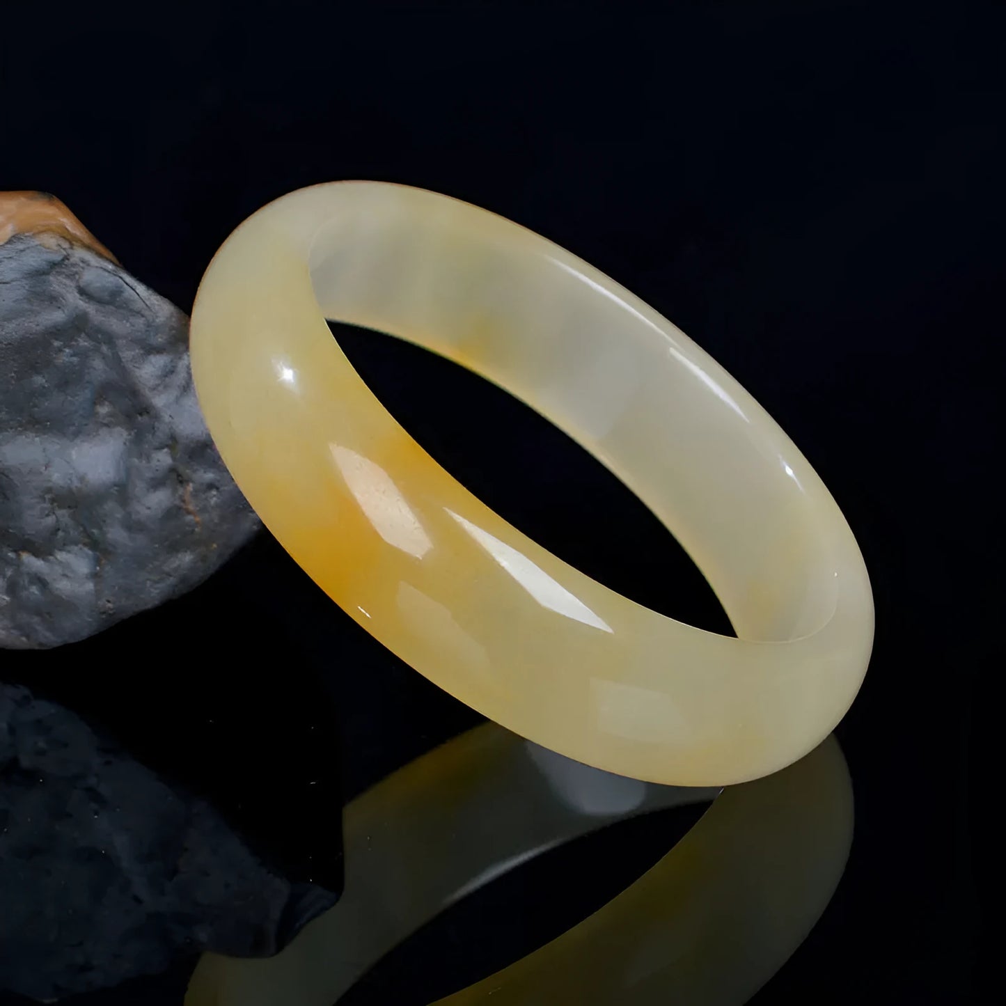A polished natural light jade bracelet in a traditional Chinese style, shown on a wrist.